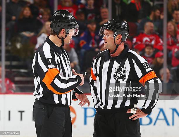 Referees Wes McCauley and Kyle Rehman talk during a timeout during the game between the New Jersey Devils and the Columbus Blue Jackets at the...