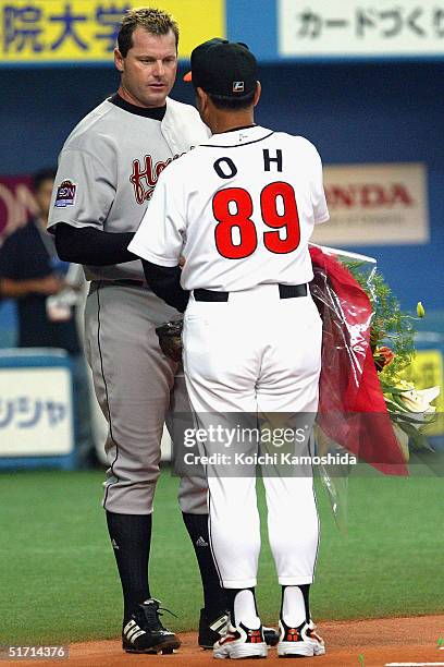 Pitcher Roger Clemens of the Houston Astros receives a bouquet of flowers from Sadaharu Oh, manager of the Daiei Hawks, during the 5th game of the...