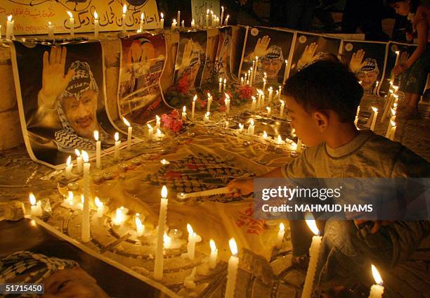 Palestinian boy lights candles in support of veteran leader Yasser Arafat 10 November 2004 at the Unknown soldier square in Gaza City amid rumors on...