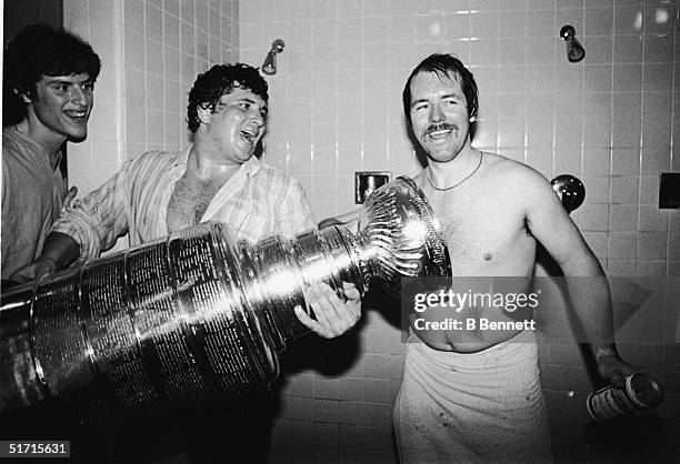 Canadian hockey player Billy Smith , goaltender for the New York Islanders, celebrates with the Stanley Cup in the shower after the Islanders...