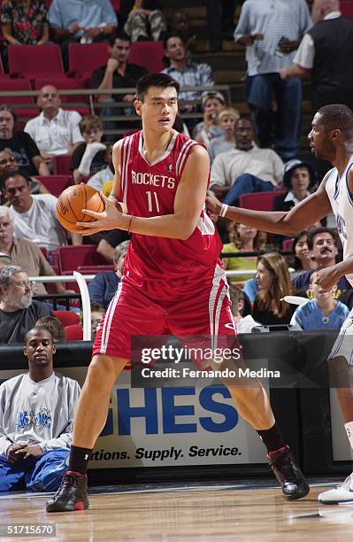 Yao Ming of the Houston Rockets is defended by Kelvin Cato of the Orlando Magic during the preseason game at TD Waterhouse Centre on October 23, 2003...