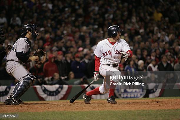 Bill Mueller of the Boston Red Sox hits a game tying single in the ninth inning during game four of the ALCS against the New York Yankees at Fenway...