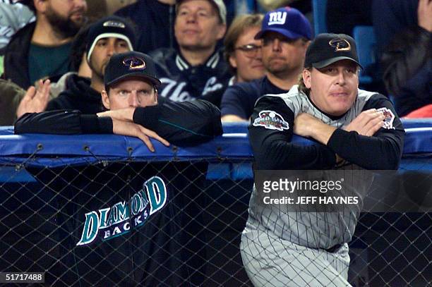 Arizona Diamondbacks pitchers Curt Schilling and Randy Johnson watch the play from the dugout during thef fifth inning of Game 5 of the World Series...