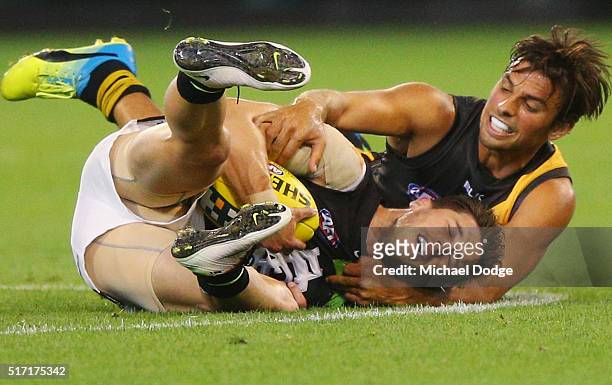 Sam Lloyd of the Tigers tackles Marc Murphy of the Blues during the round one AFL match between the Richmond Tigers and the Carlton Blues at...