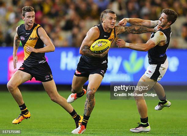 Dustin Martin of the Tigers fends off Marc Murphy of the Blues during the round one AFL match between the Richmond Tigers and the Carlton Blues at...