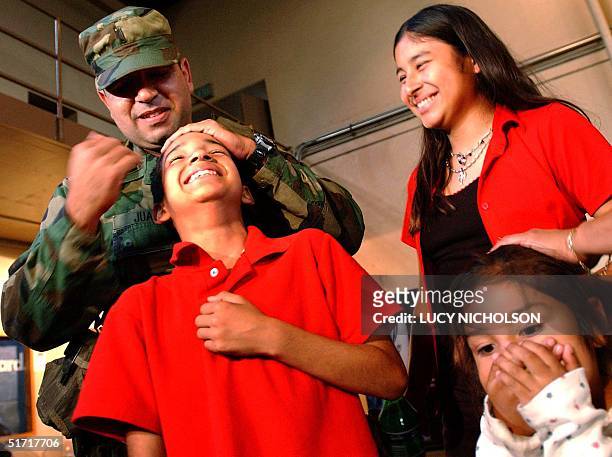 National Guard 1st Lieutenant Luis Juarez hugs his children goodbye as he leaves for training at Fort Carson, Colorado, from Glendale, CA, 08 October...