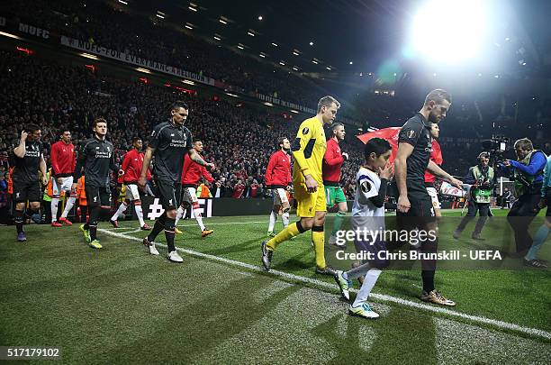 The two teams walk out ahead of the UEFA Europa League round of 16 second leg match between Manchester United and Liverpool at Old Trafford on March...