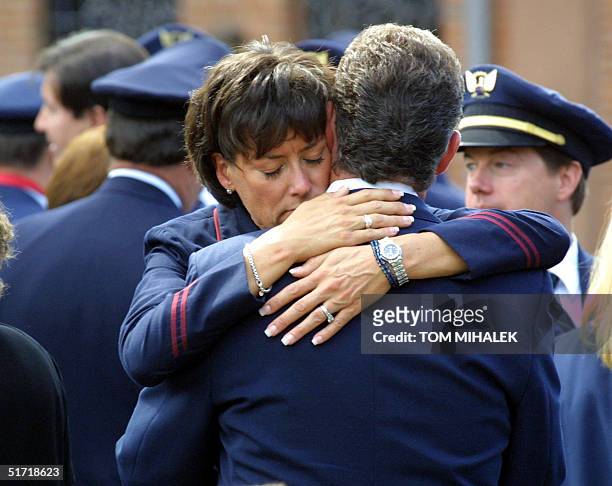 Two employees of United Airlines hug each other following the Funeral Mass, 17 September 2001, for fellow pilot Michael Horrocks who died Tuesday...