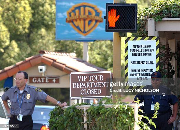 Security guards watch traffic at the main entrance to Warner Bros. Studios, in Los Angeles, 21 September 2001. Hollywood studios tightened security...