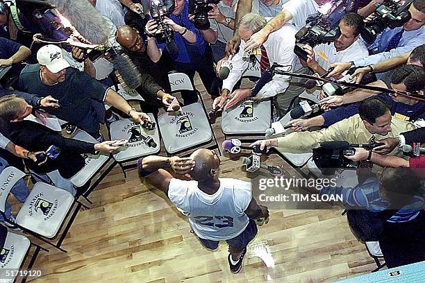 Michael Jordan is surrounded by reporters after his first practice on opening day of the Washington Wizards training camp 02 October at the...