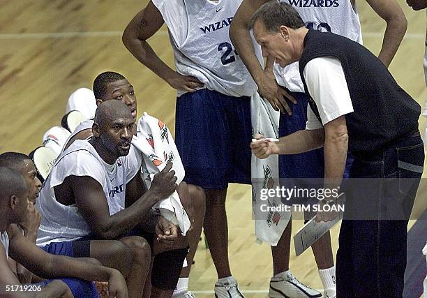 Michael Jordan listens to Washington Wizards' Head Coach Doug Collins during a timeout at an evening scrimage against teammates at the Wizards'...