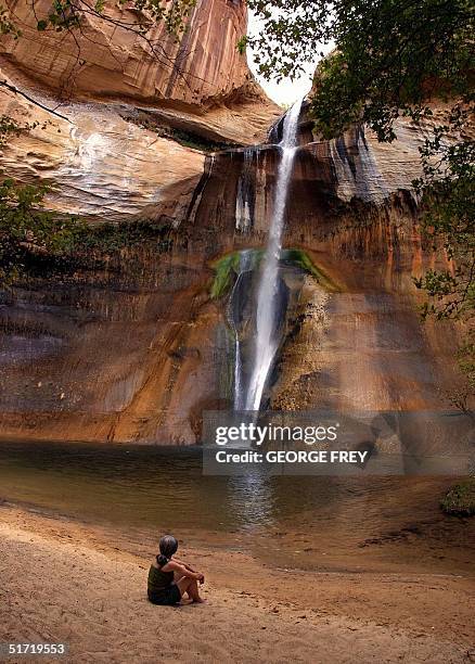 Cheryl Loitz, from Mountain Home, Arkansas sits at the base of Calf Creek Falls in The Grand Staircase-Escalante National Monument in southern Utah...