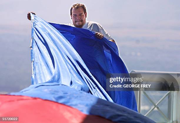 Rod Hall helps unfold a 180' x 127' American flag on top of the Salt Lake Olympic Committee's 24 storey building in downtown Salt Lake City, Utah, 19...