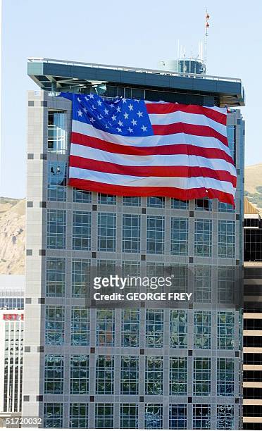 Salt Lake Olympic Committee workers unfold a 180' x 127' American flag on top of the SLOC 24 storey building in downtown Salt Lake City, Utah, 19...