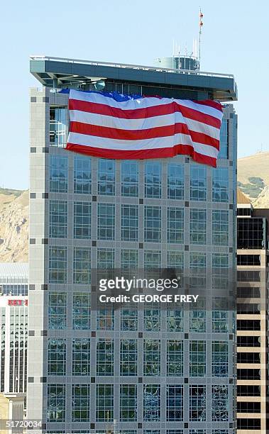 Salt Lake Olympic Committee workers unfold a 180' x 127' American flag on top of the SLOC 24 storey building in downtown Salt Lake City, Utah, 19...
