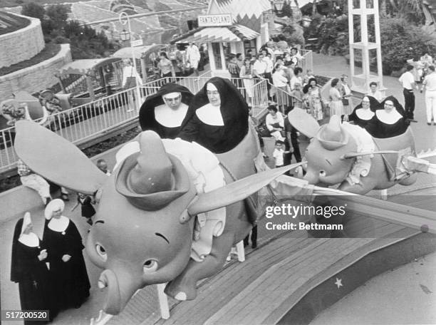 Catholic School Day at Disneyland and Sisters Mary William and Mary Alfred take the first elephant as Sisters Mary Yvonne and Mary Joachin follow...