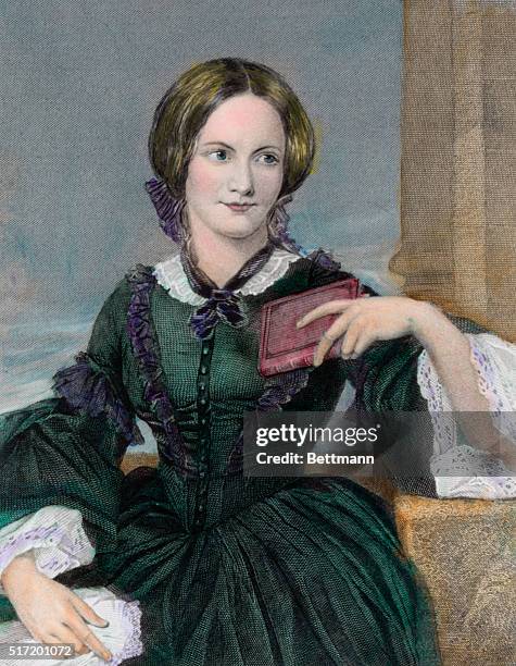 English novelist Charlotte Bronte , seated with a small book in hand.