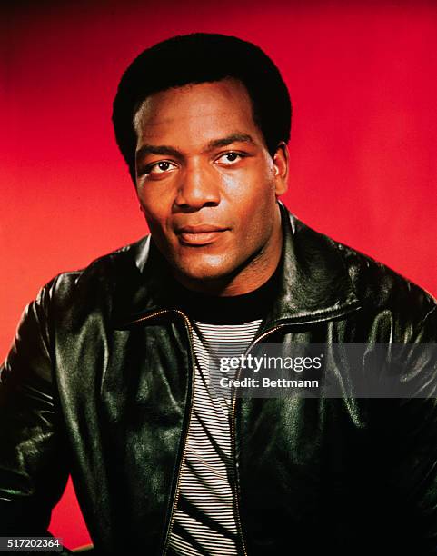 Publicity handout of ex-football player turned actor Jim Brown. He is wearing a black leather jacket with a black and white stripped shirt underneath...