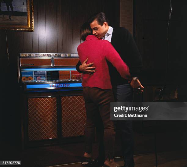 Young couple show dancing in front of a jukebox. Ca. Late 1950's to 1960's.