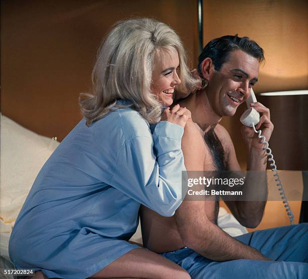 James Bond and Jill Masterson share a laugh on the phone in the James Bond flick, Goldfinger. 1964.