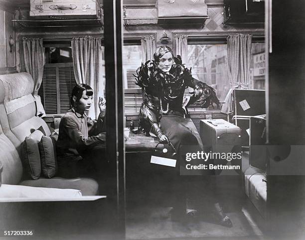 Anna May Wong and Marlene Dietrich sit pensively in their luggage-filled compartment. Movie still from 'Shanghai Express," 1932.