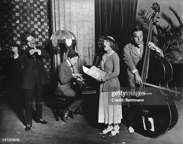 Musical quartet: Charlie Chaplin with violin, Mary Pickford singing and Douglas Fairbanks, Sr., with string bass.