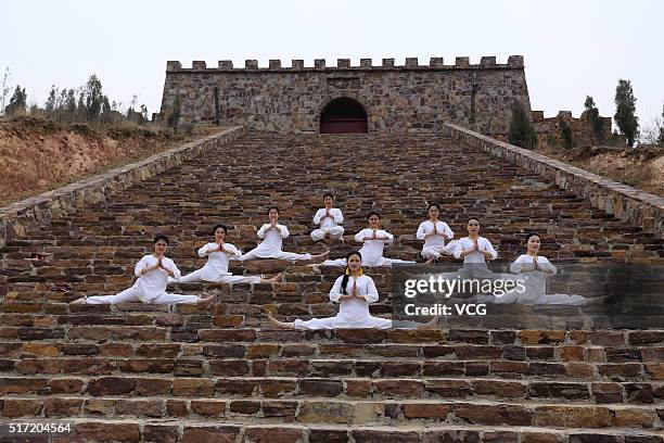 Women do yoga on the precipice of Mount Song on March 23, 2016 in Zhengzhou, Henan Province of China. Over 10 yoga enthusiasts practice on the...