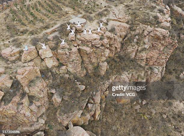 Women do yoga on the precipice of Mount Song on March 23, 2016 in Zhengzhou, Henan Province of China. Over 10 yoga enthusiasts practice on the...