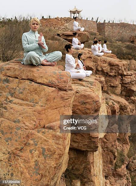 Women do yoga on the precipice of Mount Song on March 23, 2016 in Zhengzhou, Henan Province of China. Over 10 yoga enthusiasts practice on the...