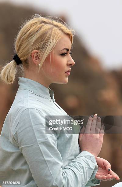 Foreign woman does yoga on the precipice of Mount Song on March 23, 2016 in Zhengzhou, Henan Province of China. Over 10 yoga enthusiasts practice on...