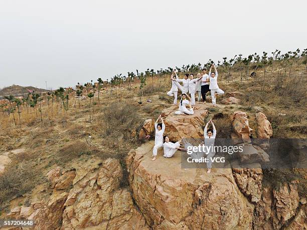 Women do yoga on the precipice of Mount Song on March 23, 2016 in Zhengzhou, Henan Province of China. Over 10 yoga enthusiasts practice on the...