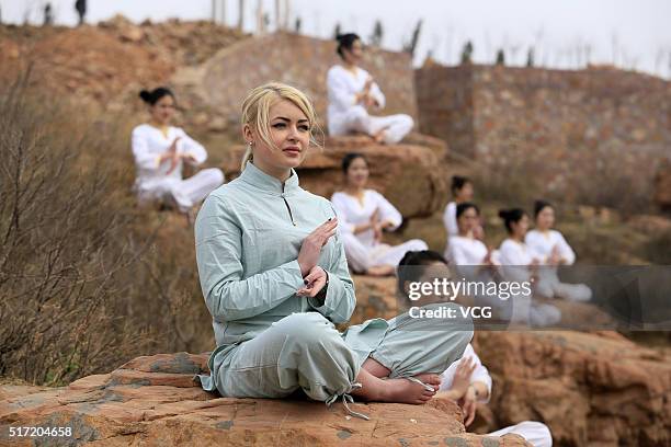 Women do yoga on the precipice of Mount Song on March 23, 2016 in Zhengzhou, Henan Province of China. Over 10 yoga enthusiasts practice on the...