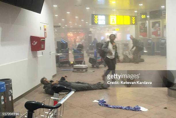 An injured man lies amongst debris following a suicide bombing at Brussels Zaventem airport on March 22, 2016 in Brussels, Belgium. Georgian...