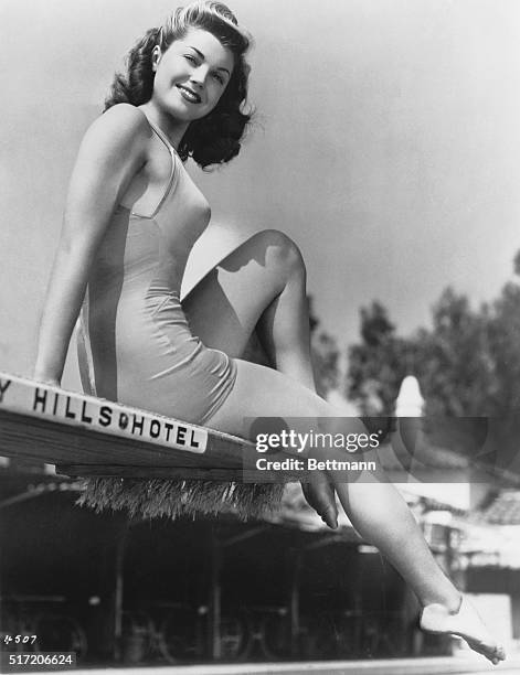 Esther Williams in bathing suit beside pool.