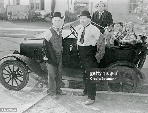 Stan Laurel and Oliver Hardy is seen here taking off their jackets in preparation for a fight while Kay Deslys, Isabella Keep, and Edgar Kennedy sit...