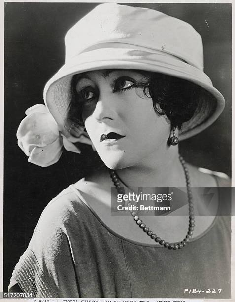 Gloria Swanson, silent movie star, wearing white hat.