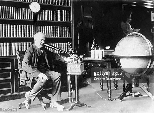 Thomas Edison is relaxing at home with one of his inventions.
