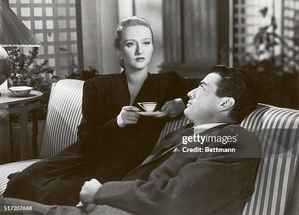 Actress Celeste Holm and actor John Garfield sit on a couch during a scene from the 1947 20th Century Fox production of "Gentleman's Agreement"....