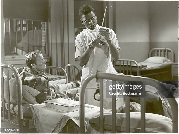 Actors Richard Widmark and Sidney Poitier in a scene of American noir film 'No Way Out', 1950. Original caption reads: 'Ray Biddle keeps up such a...