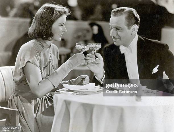 Ninotchka and Count Leon d'Algout share a toast in the 1939 MGM production Ninotchka.