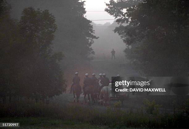 Mounted police make their way along an access road leading to the crash site of United Airlines Flight 93 through the early morning fog 12 September...