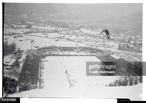 Sailing high over Garmisch-Partenkirchen and the Olympic Stadium jammed with 10,000 people is Finnish ski jumper Hemmo Silvennoinen. His spectacular...