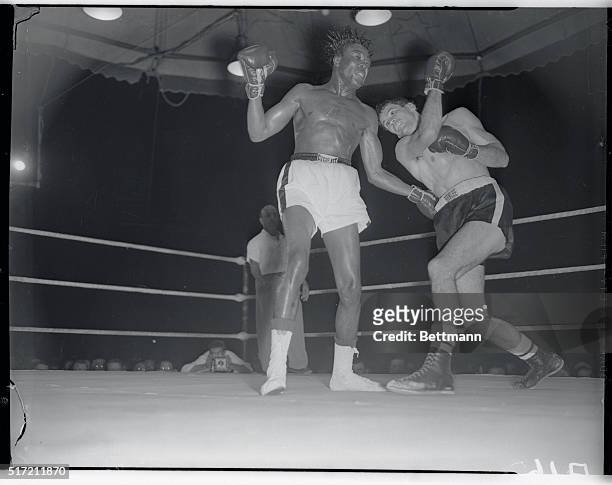 Former welterweight champ Kid Gavilan has his hair stood on end by a right punch from gangly Bobby Dykes during their 10-round bout in Miami, March...