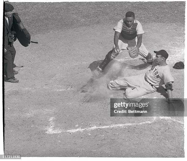 Allen Van Alstyne, Boston Red Sox outfielder, is out at home plate as Elston Howard, Yankee rookie catcher, puts tag on him in the fifth inning of...