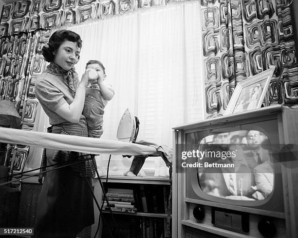 Housewife Marie Breetveld holds her son while watching the televised McCarthy-Army hearings on April 22, 1954.