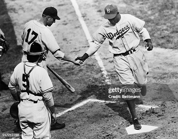 Jackie Robinson of the Brooklyn Dodgers, breaking the color barrier this season as the first African-American to play in the Major Leagues, crosses...