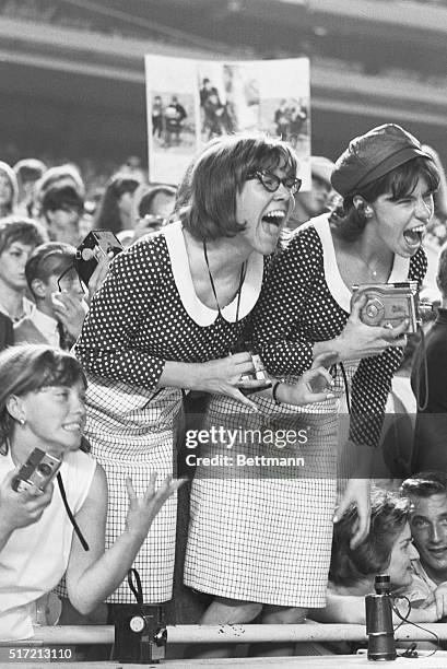 Beatles fans scream at the top of their lungs during a concert at Shea Stadium.