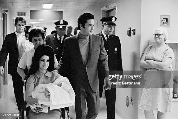 Memphis, TN: Evis Presley with his wife and daughter as they leave Baptist Hospital.