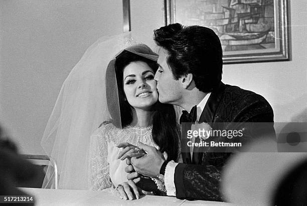 Las Vegas, NV: Elvis Presley gives his new bride, Priscilla Ann Beaulieu, a kiss following their wedding. The bride wears a large diamond on her...