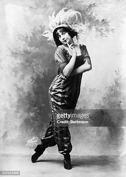 Fanny Brice headlined in "Ziegfeld Follies," 1911. Depicted alone posed with arm crossed and finger on chin, wearing a feather hat.
